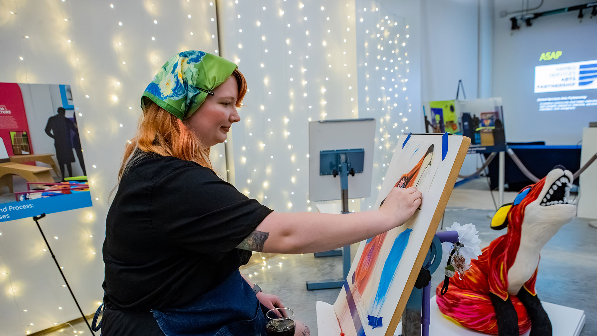 A Christopher Newport art student paints a colorful fox sculpture at the 2026 Arts for All Ball.