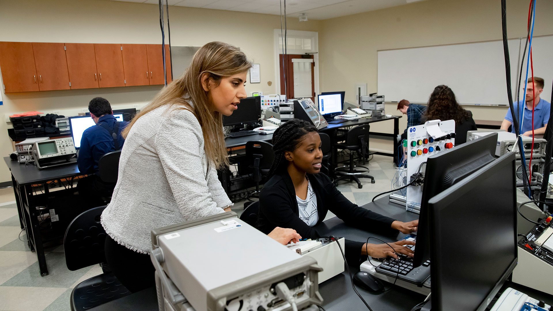 Student and professor working at a computer during class