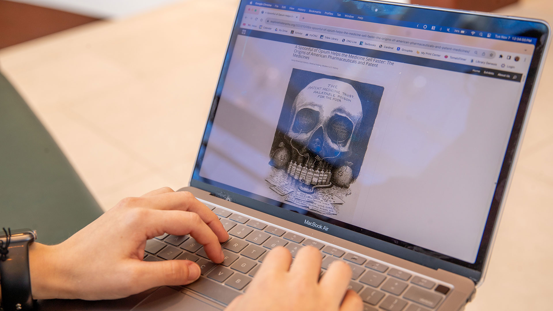 A laptop with a digital museum exhibit that shows an illustration of a skull