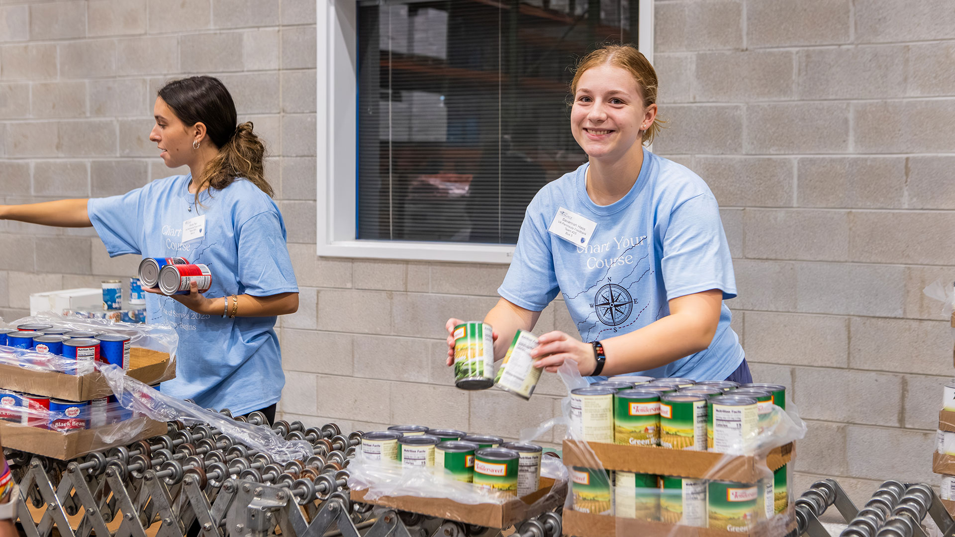 A student unpacks canned goods on an assembly line.