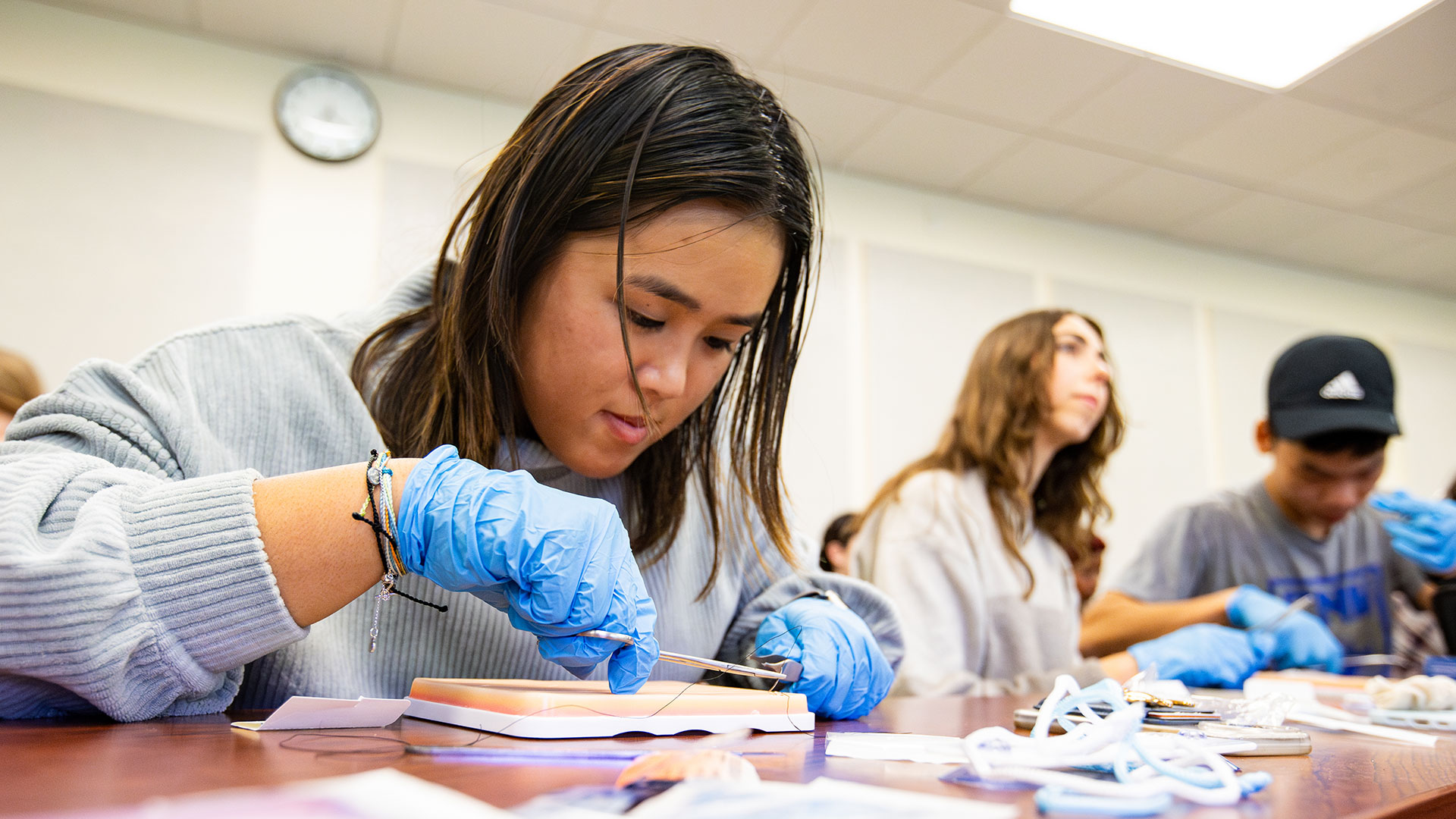 Pre-med student demonstrates how to suture