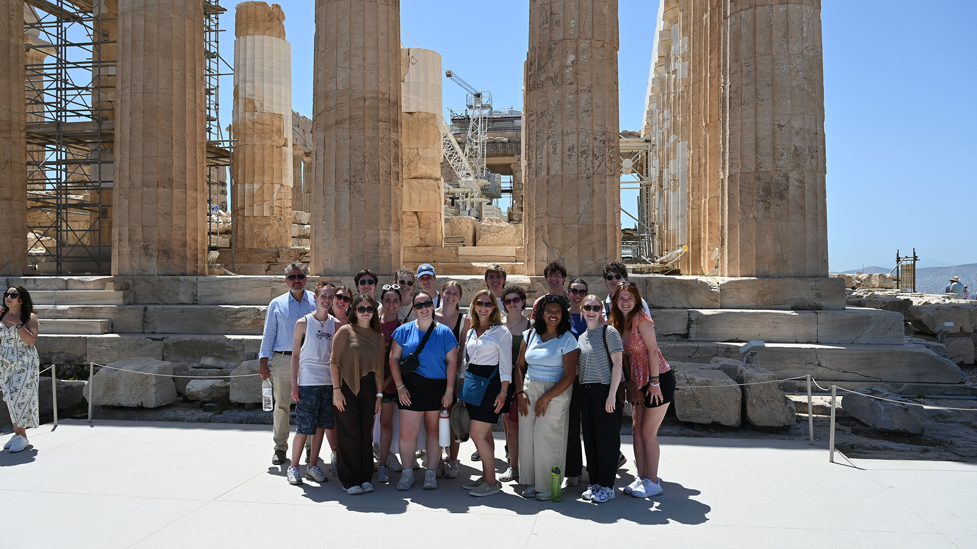 Group photo of students and professors in front of Grecian ruins