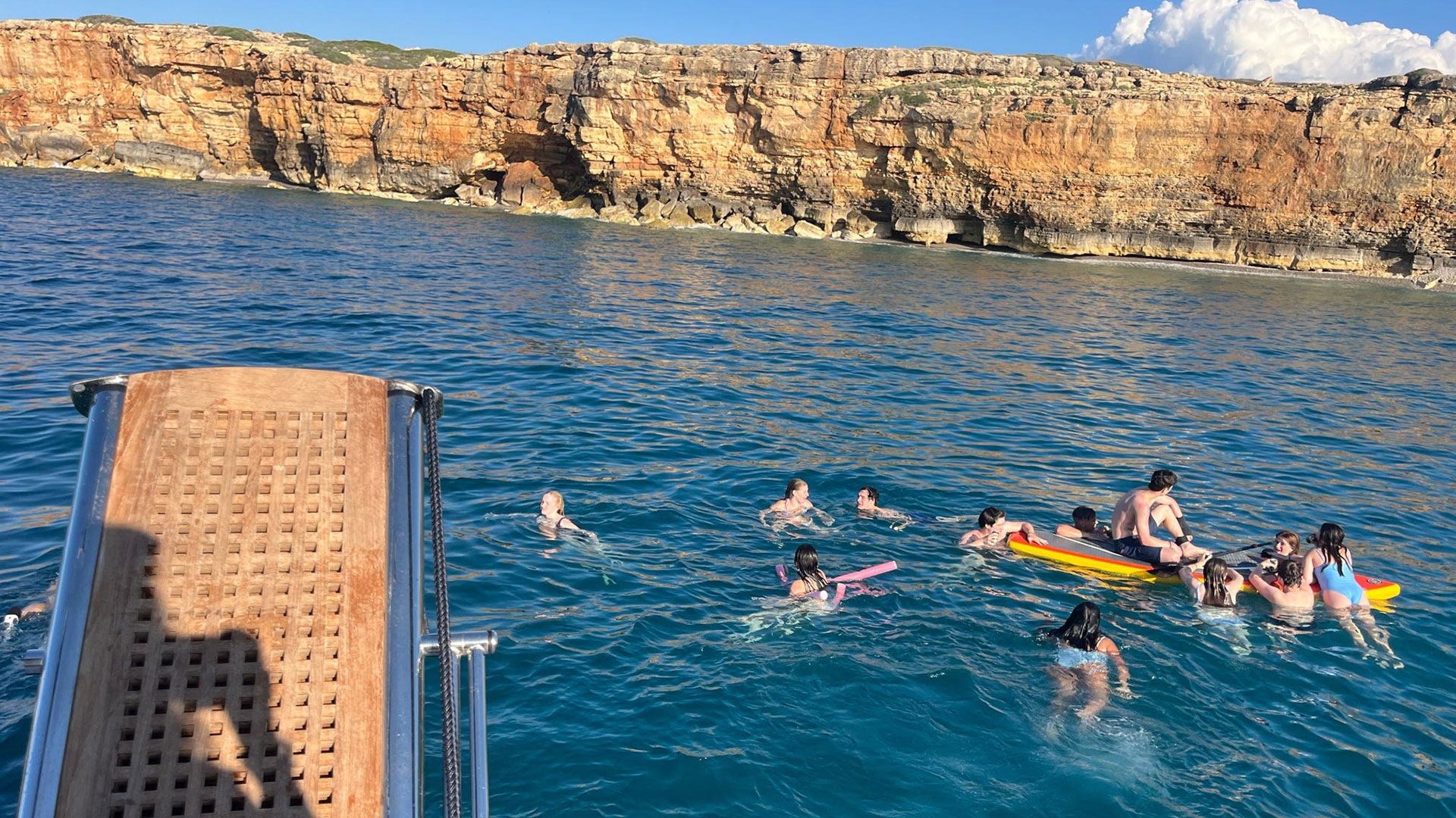 Students float and swim in a body of water in Greece.
