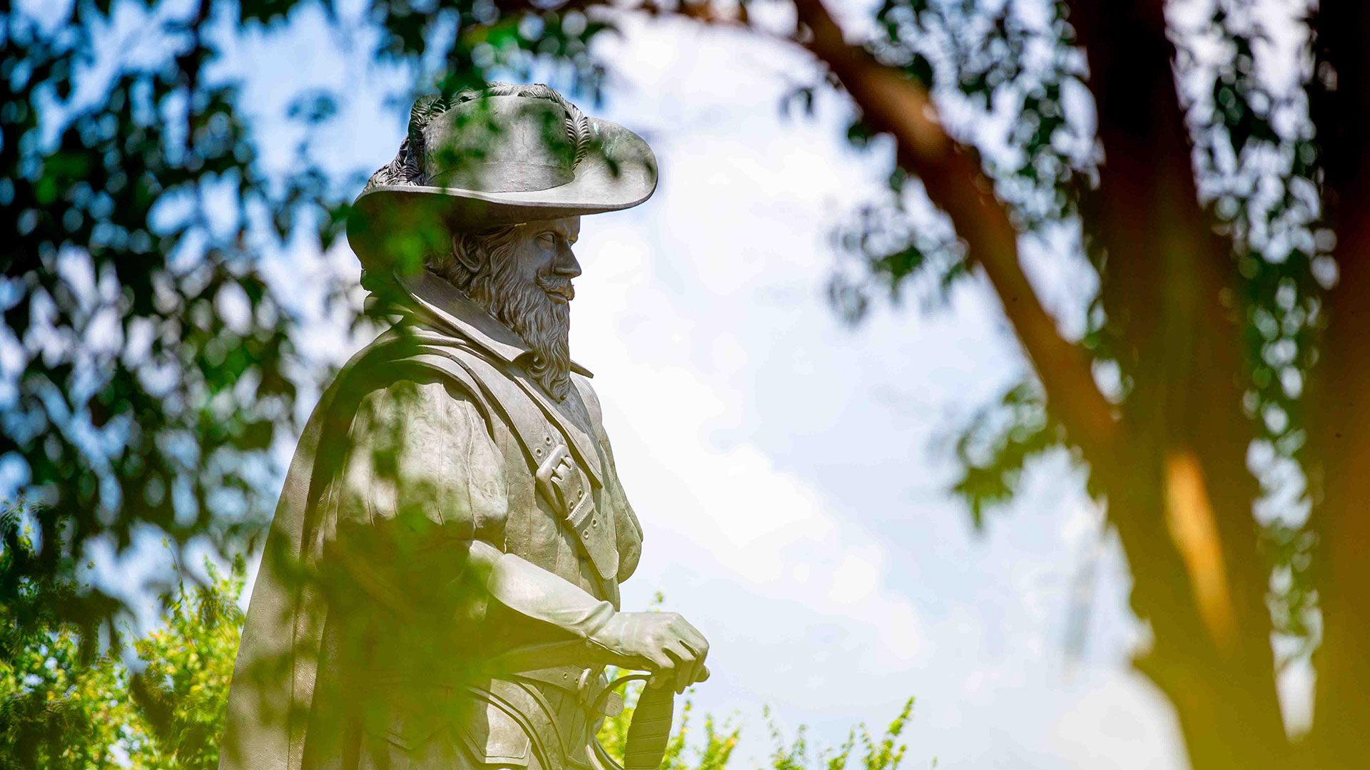Statue of Captain Chris framed by tree branches