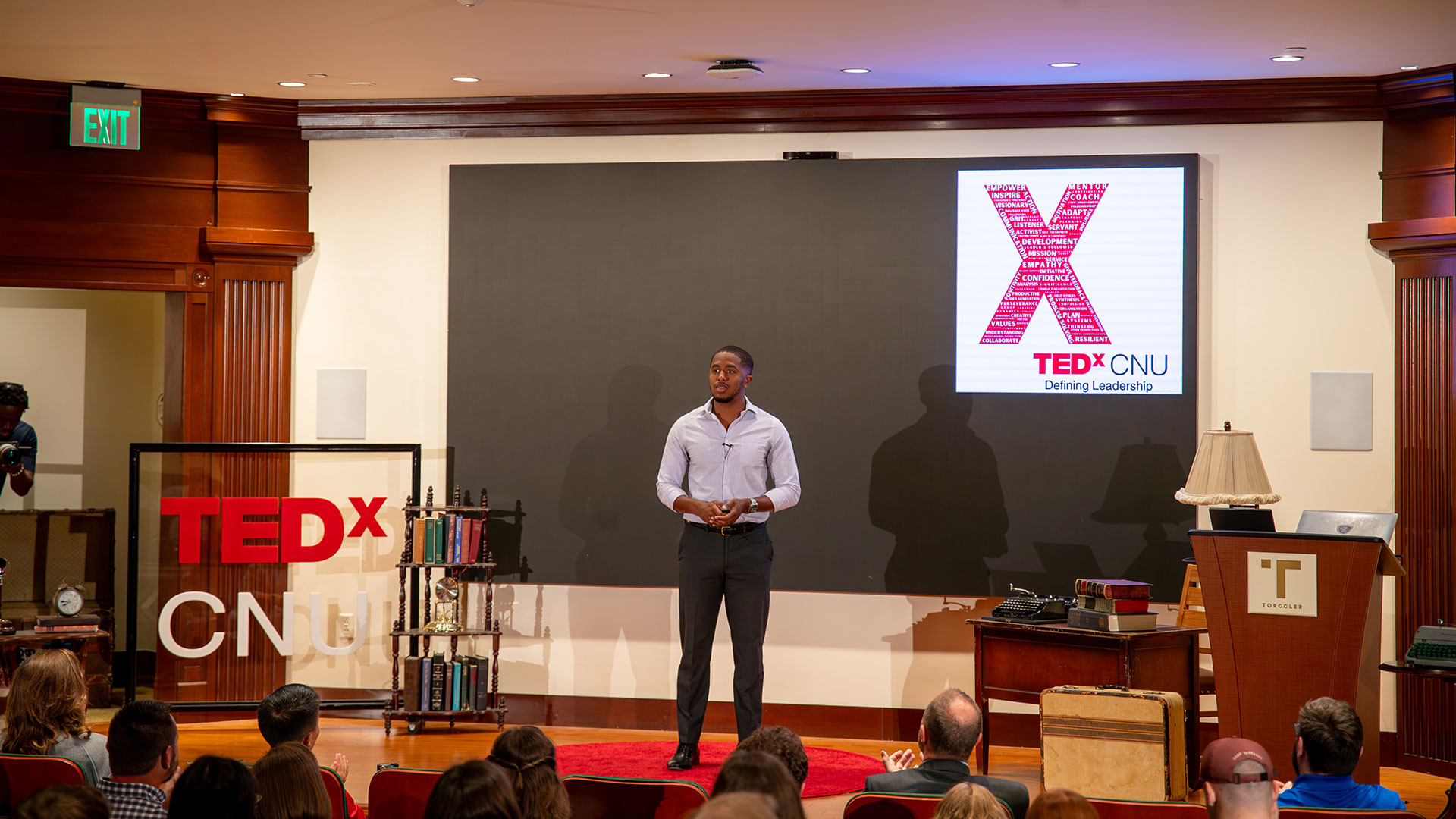 Student standing on a stage giving a talk about leadership