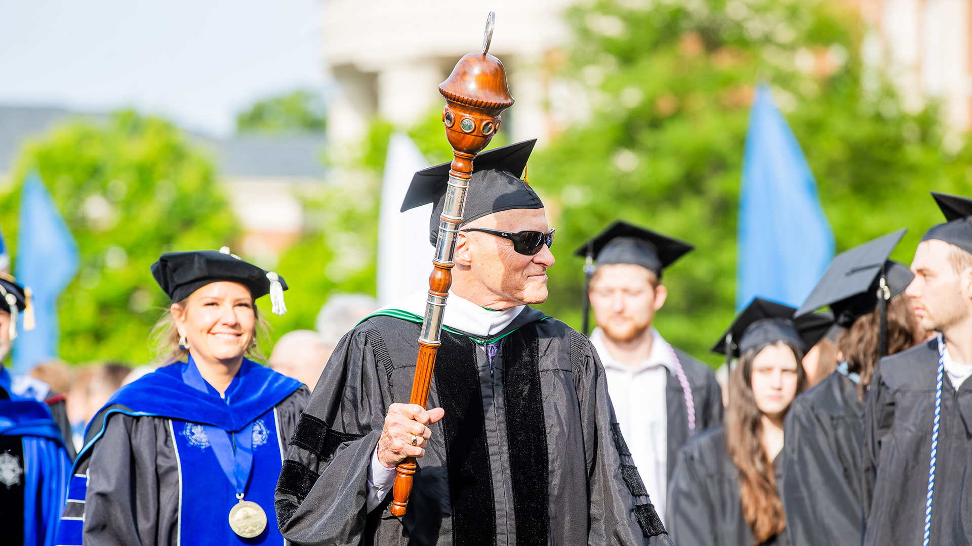 Jay Paul holds the mace during Commencement