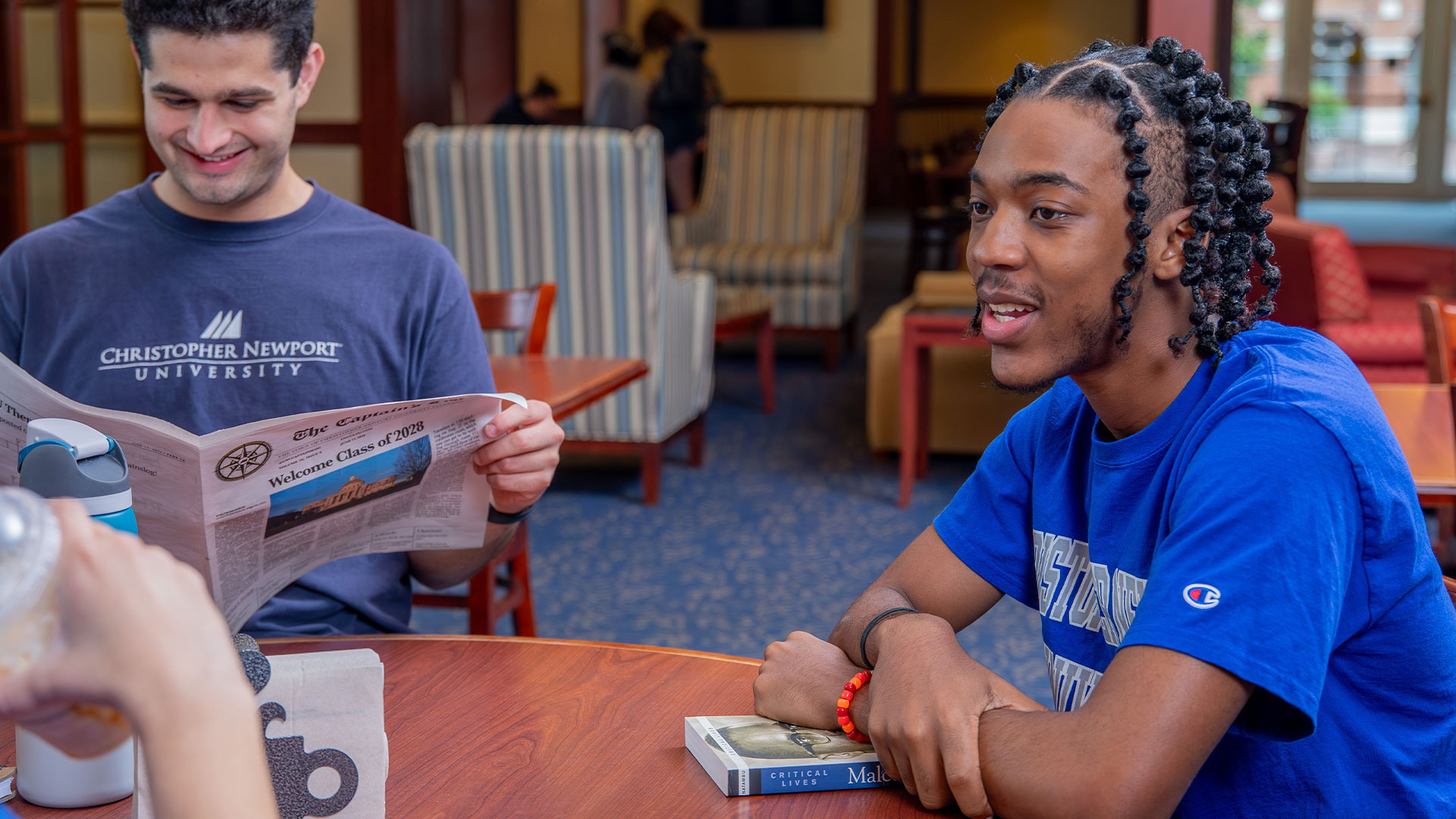 Two students sit at a table talking
