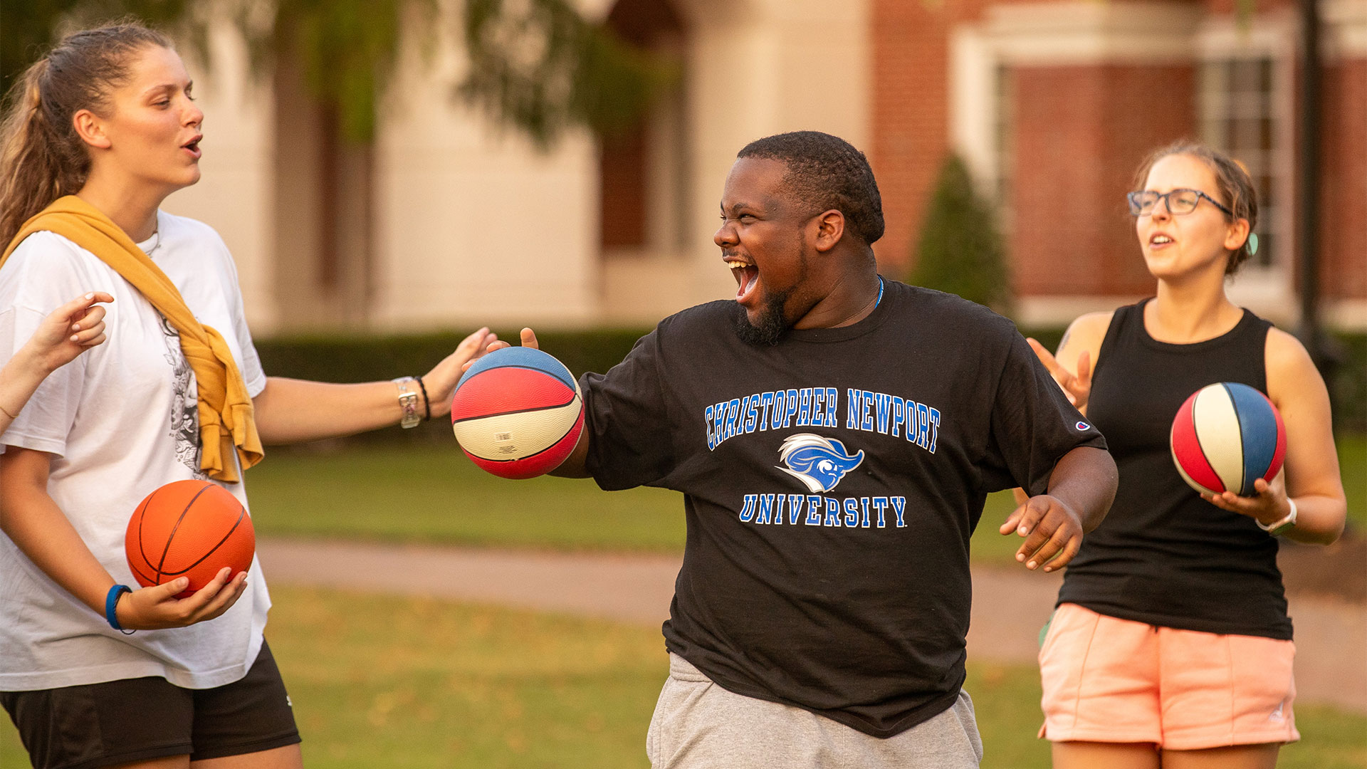 Students play with basketball on the great lawn at a CNU student block party.